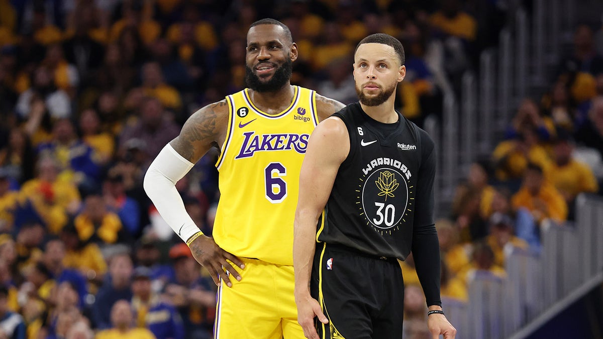LeBron James stands next to Steph Curry