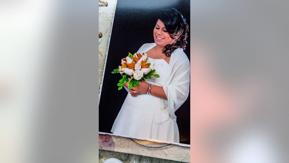 Leidy Figueroa is pictured wearing a wedding dress and holding flowers