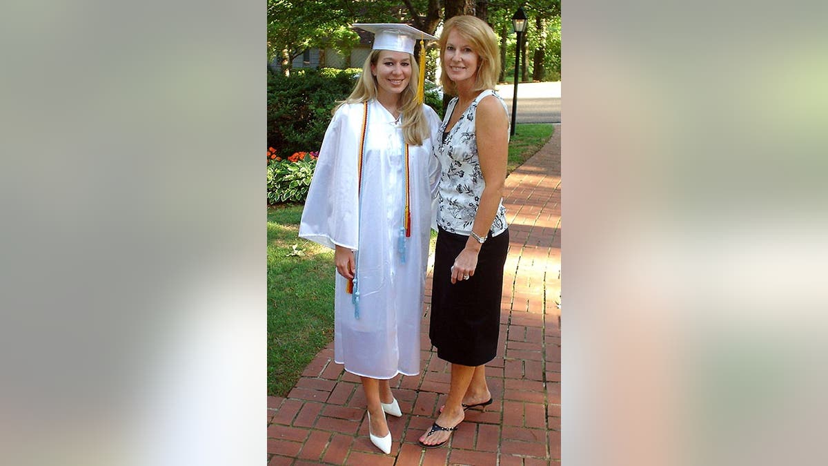 Natalee is in a white cap and gown as she stands with her mother, Beth