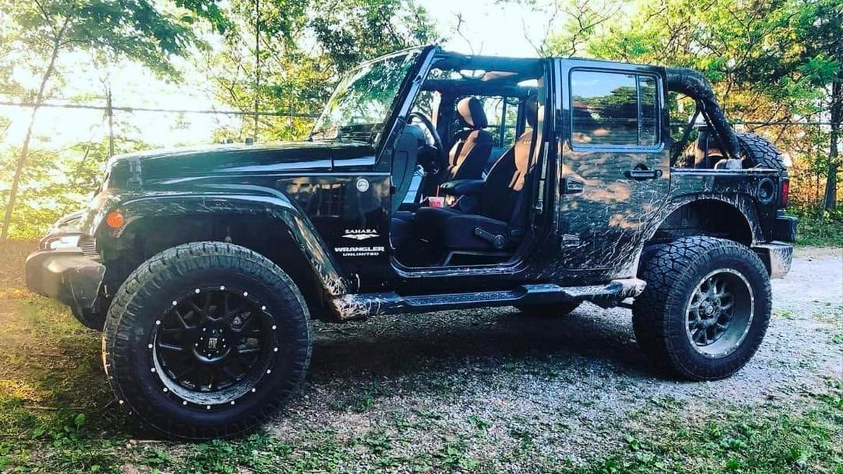 Black Jeep Wrangler with mud splashed on sides