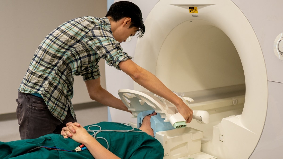 Jerry Tang puts a patient in an fMRI scanner