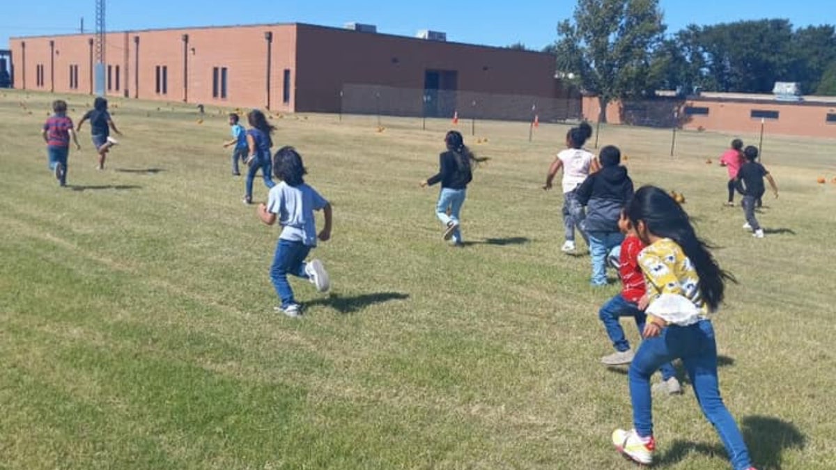 children playing in field outside school