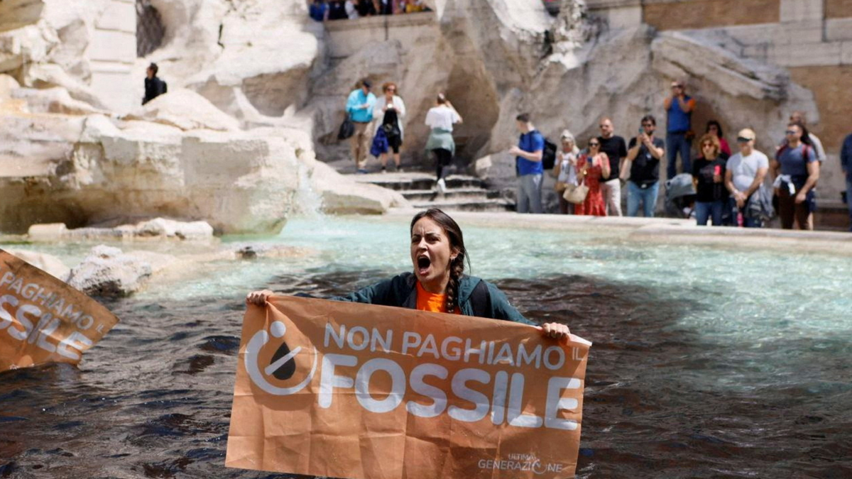 Protester holds sign at Trevi Fountain in Rome, Italy