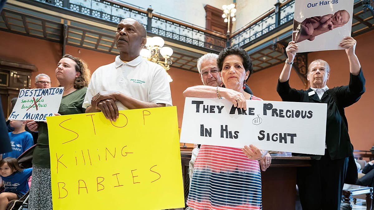 Demonstrators gather with placards and signs in the lobby of the South Carolina Statehouse, where the Gov. Henry McMaster called the House of Representatives back into session in Columbia, South Carolina, May 16, 2023.