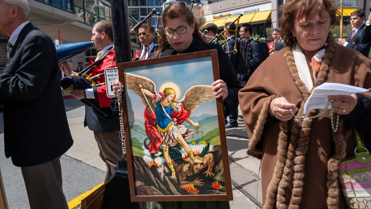 Christian protester with Archangel Michael painting