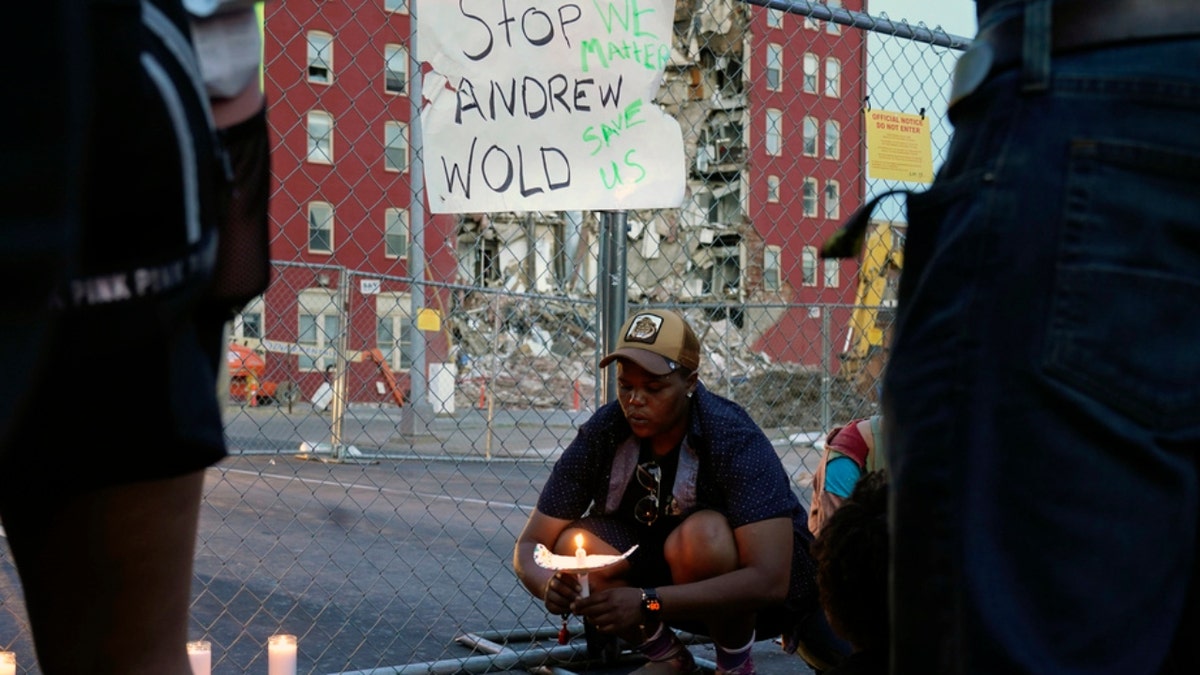 A vigil outside the scene of where an apartment building partially collapsed