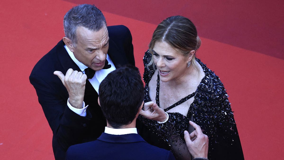 Tom Hanks talks to a staff member at Cannes