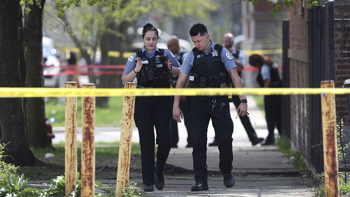 Two Chicago police officers walking on the sidewalk.