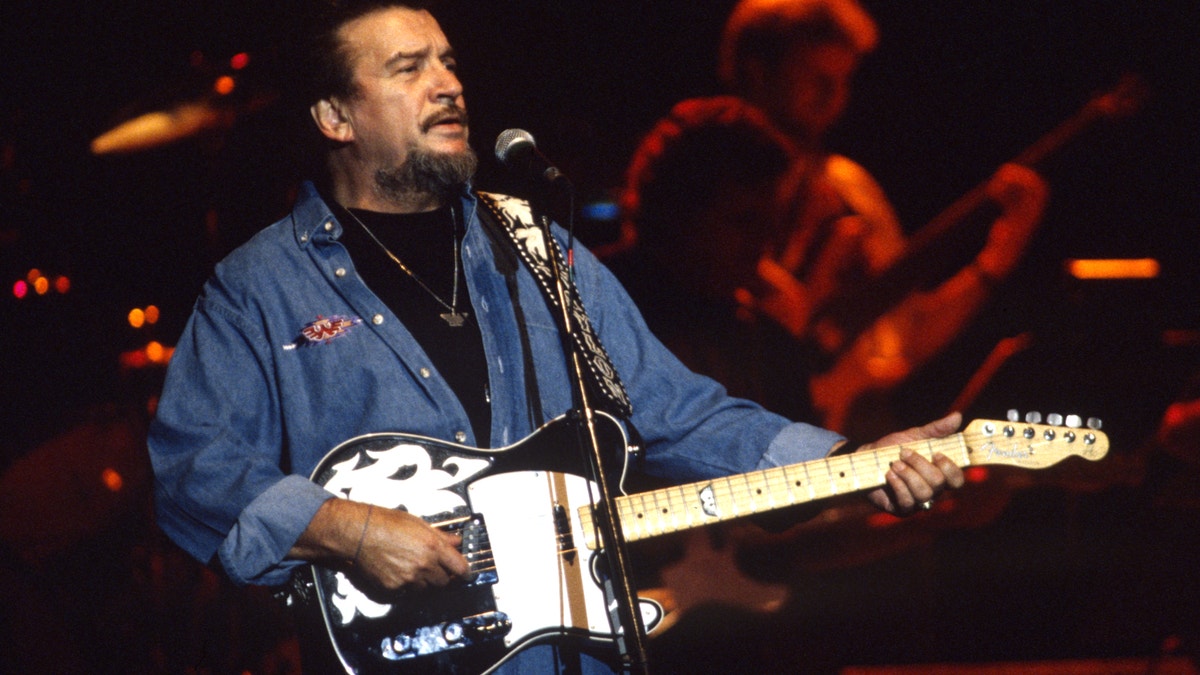 Waylon Jennings holding a guitar