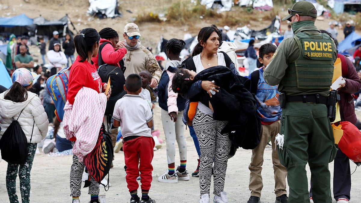 Border patrol agent speaks with migrant at border