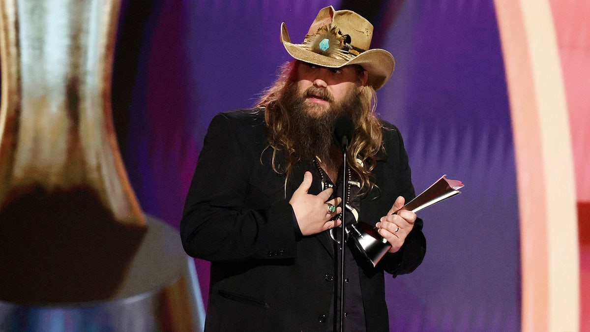 Chris Stapleton wears brown leather hat and black blazer to accept entertainer of the year award at acms