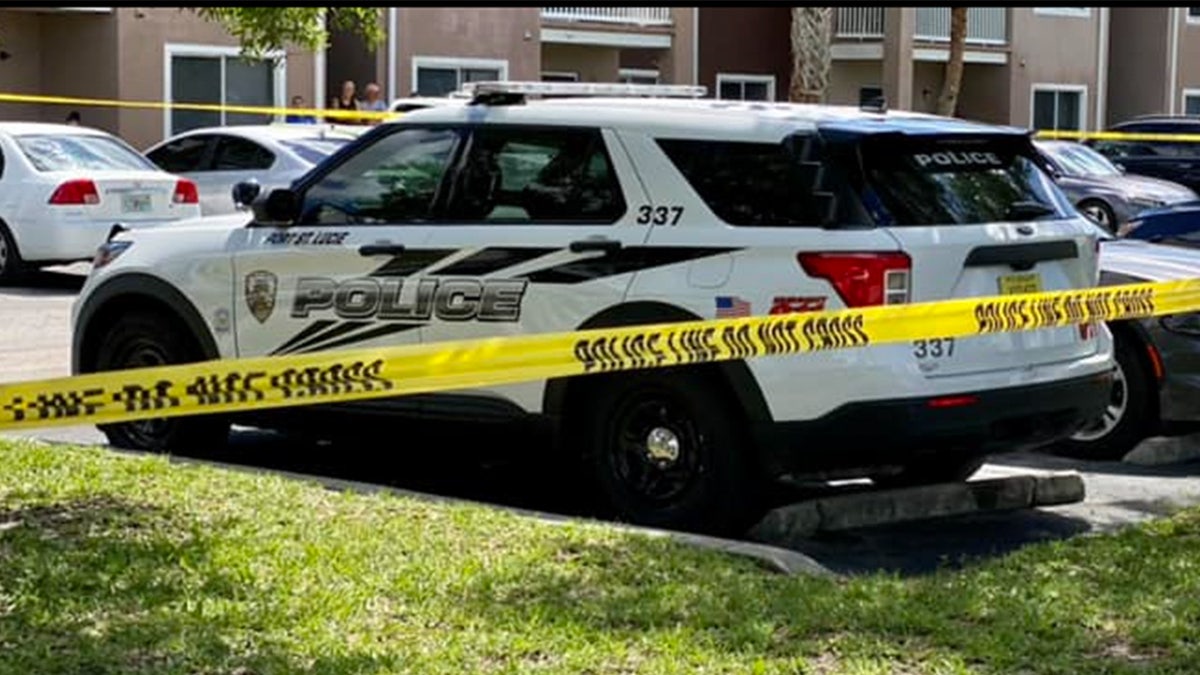 Police cruiser in front of a yellow caution tape.