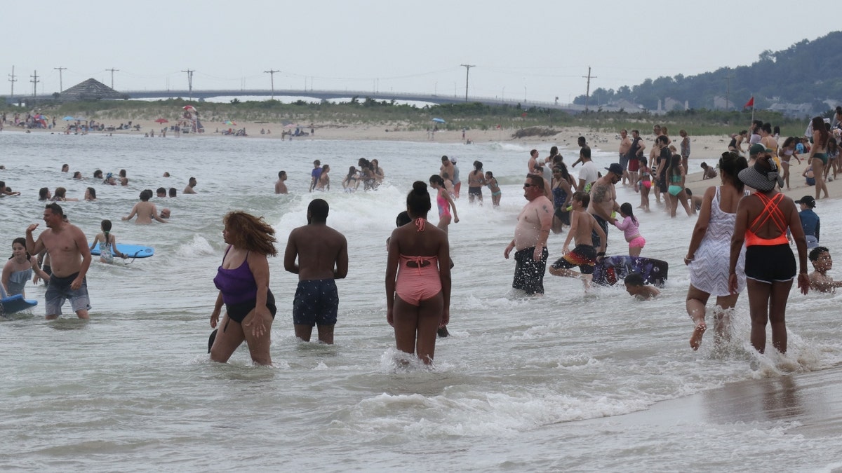 People swim in the Atlantic Ocean on a beach at Sandy Hook