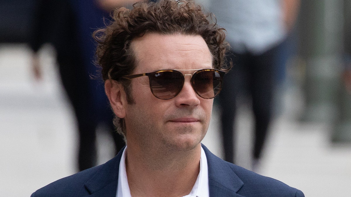 Danny Masterson in a blue blazer and white shirt with dark shades on goes to court