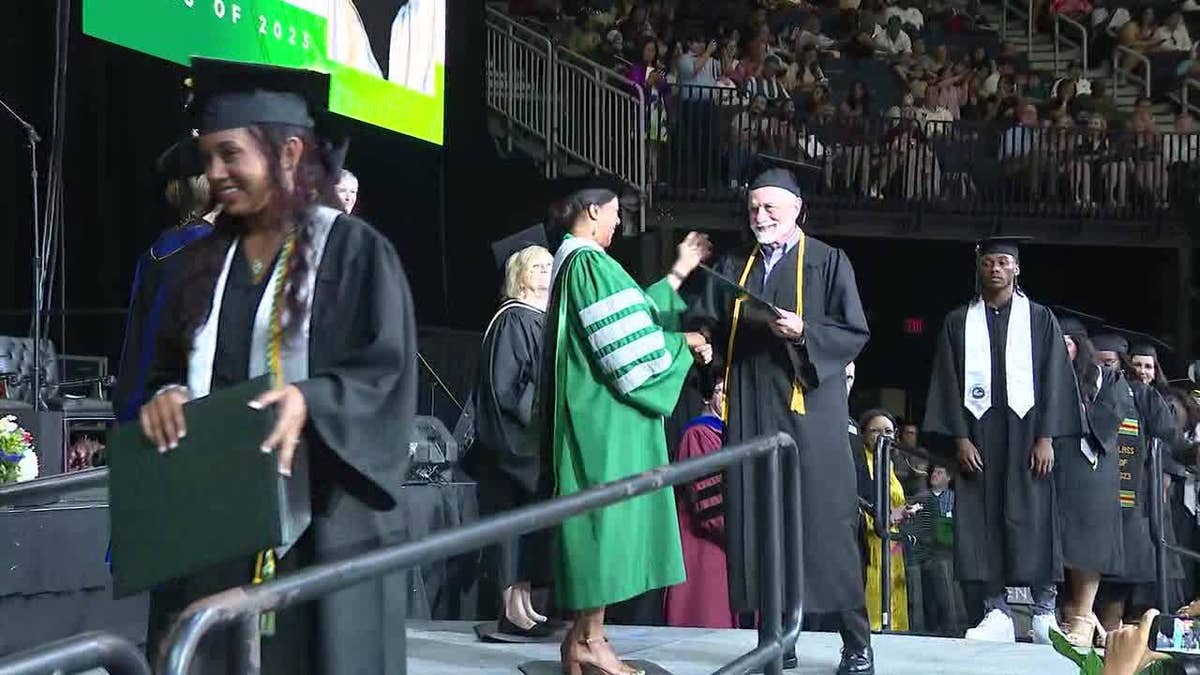 Sam Kaplan walking across stage