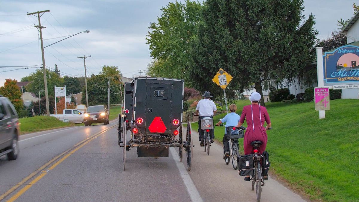 Members of the Amish riding bikes and horse-and-buggies.