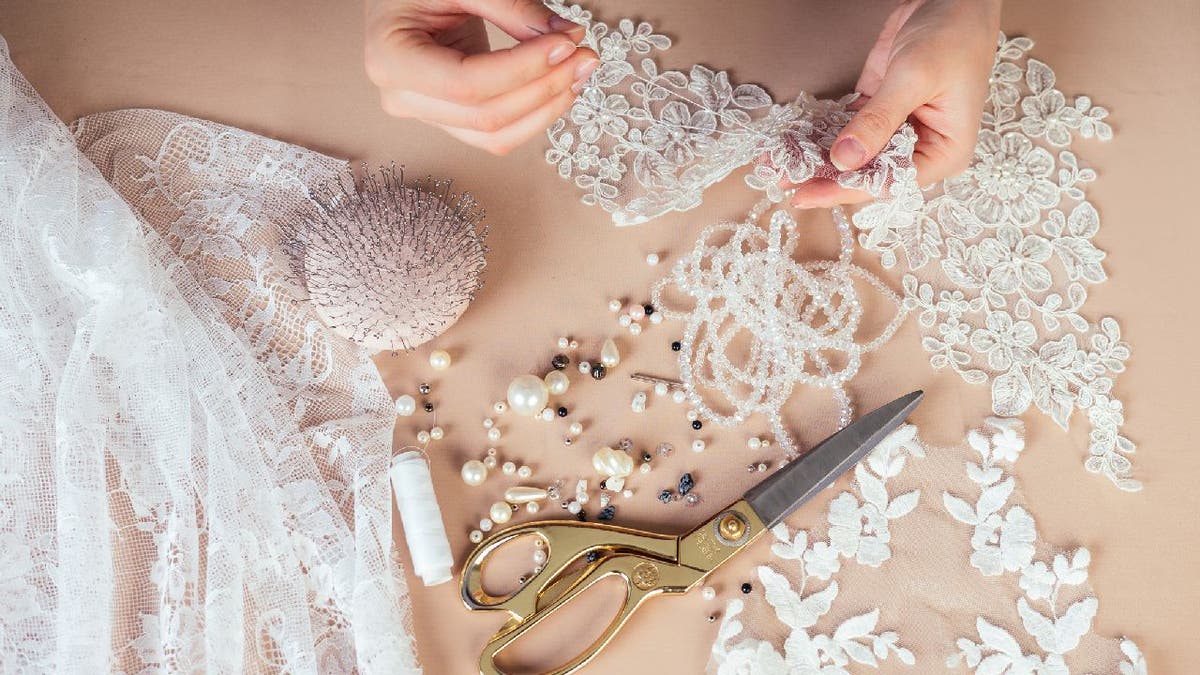 Bridal wear designer works with lace cuttings.