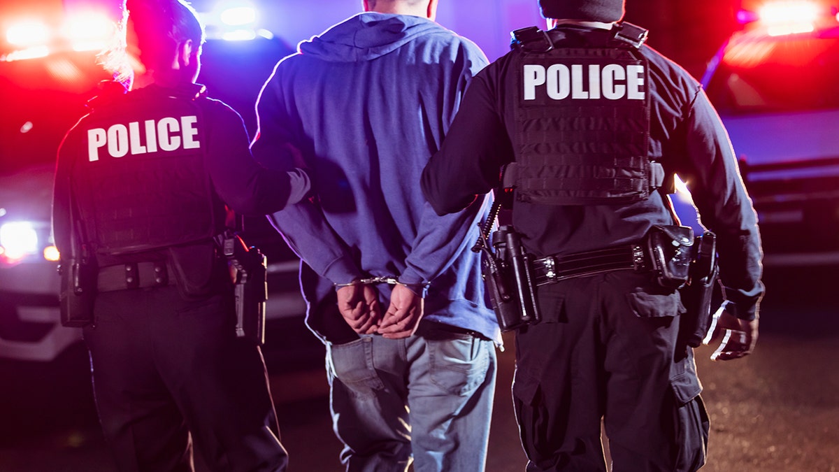 police walk arrested man forward