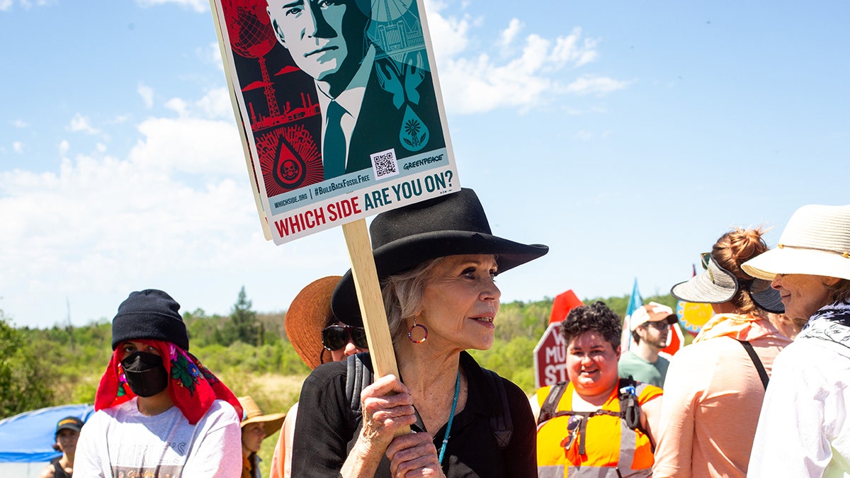 Jane Fonda holding protest sign