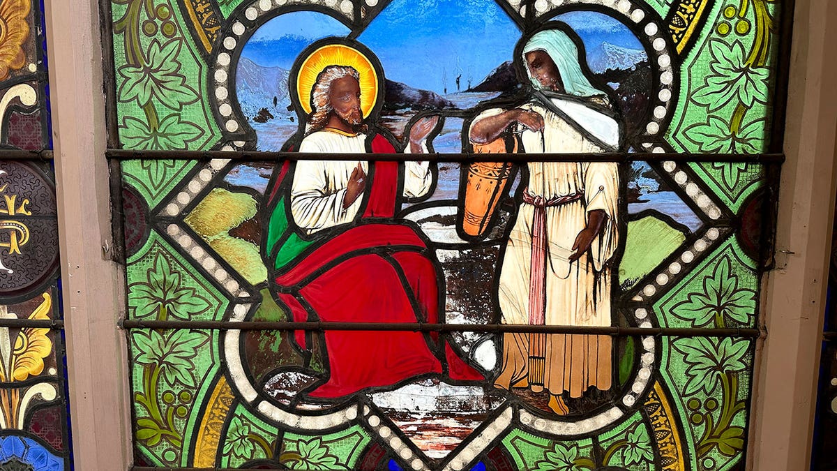 Stained glass depiction of a dark-skinned Jesus with Samaritan woman