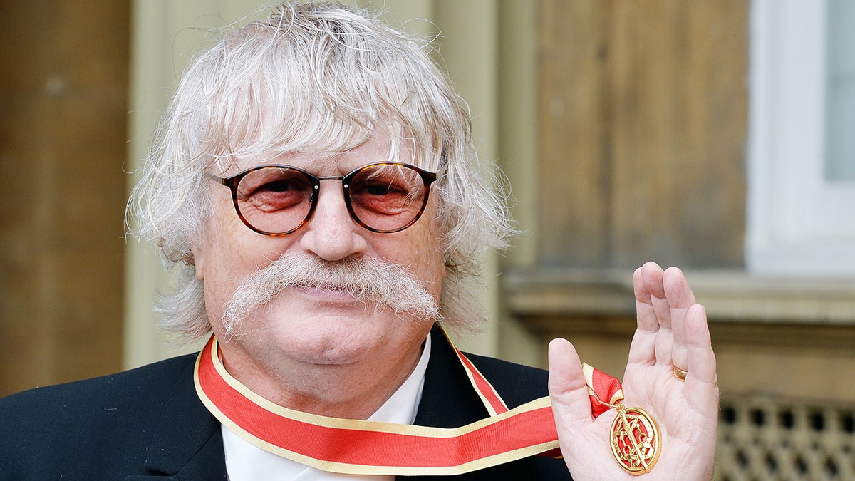 Sir Karl Jenkins holding his knighthood award