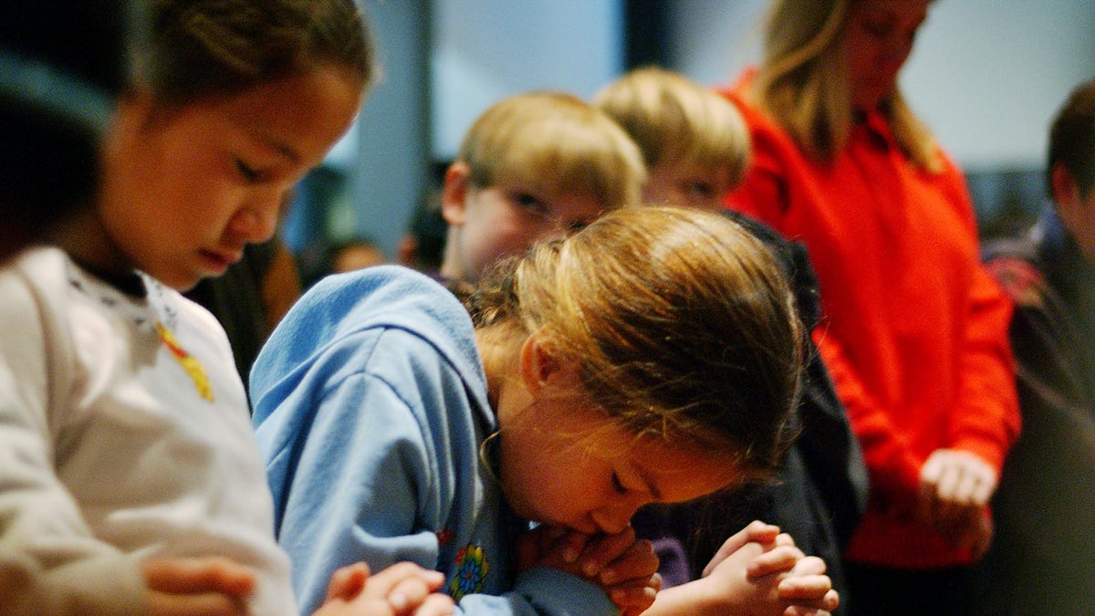 Susan (no last names released) bows her head in prayer as she and fellow fourth-grader Carolyne (L) attend a prayer service to give thanks that no one has died since a car plowed into 12 children, including Vanessa, and three teachers the day before at Westminster Academy Christian Day School, Jan. 31, 2002, in Eagle Rock near Los Angeles, Calif.