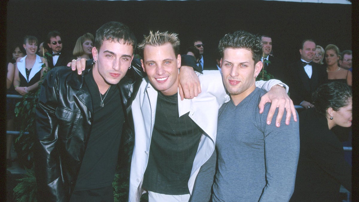LFO poses for a photo with their arms around each other at an event.
