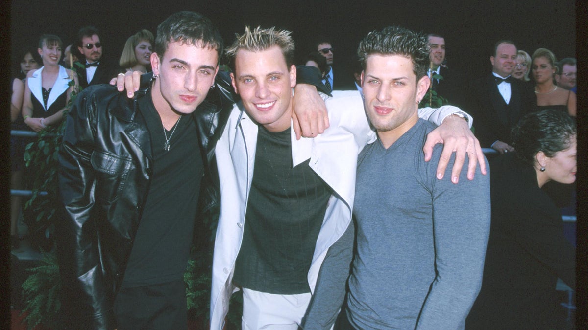 LFO poses for a photo with their arms around each other at an event.