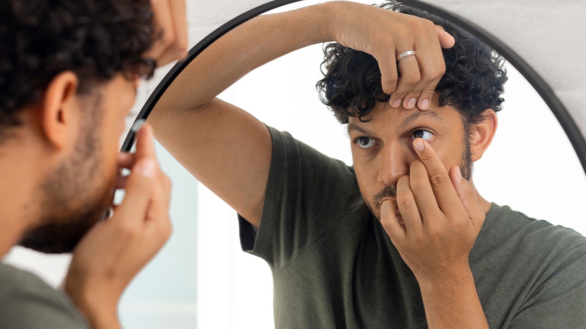 Man putting in contacts