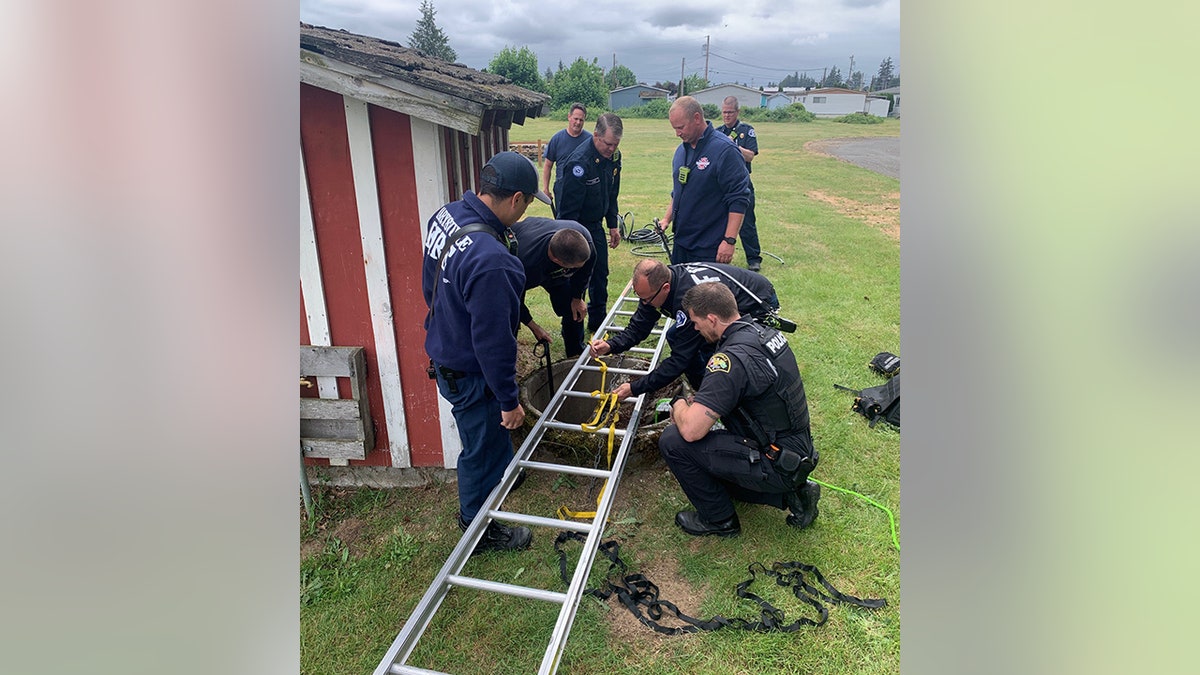 firefighters bringing ladder to well