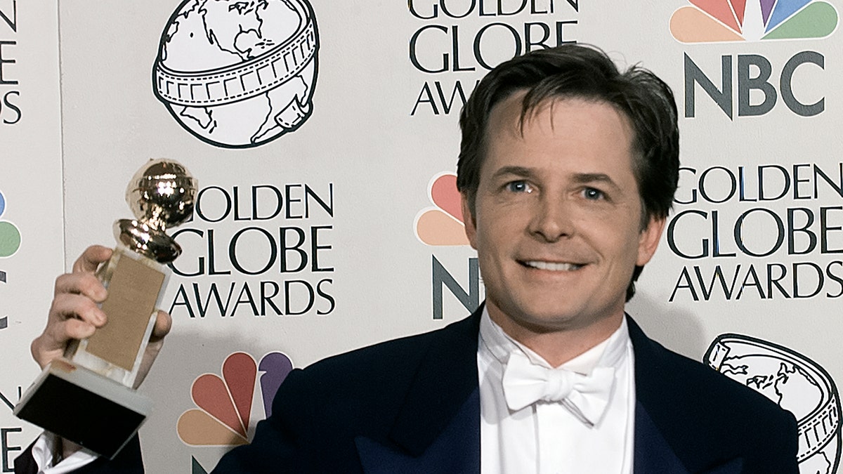 Michael J. Fox poses with his award at the 1998 Golden Globes.