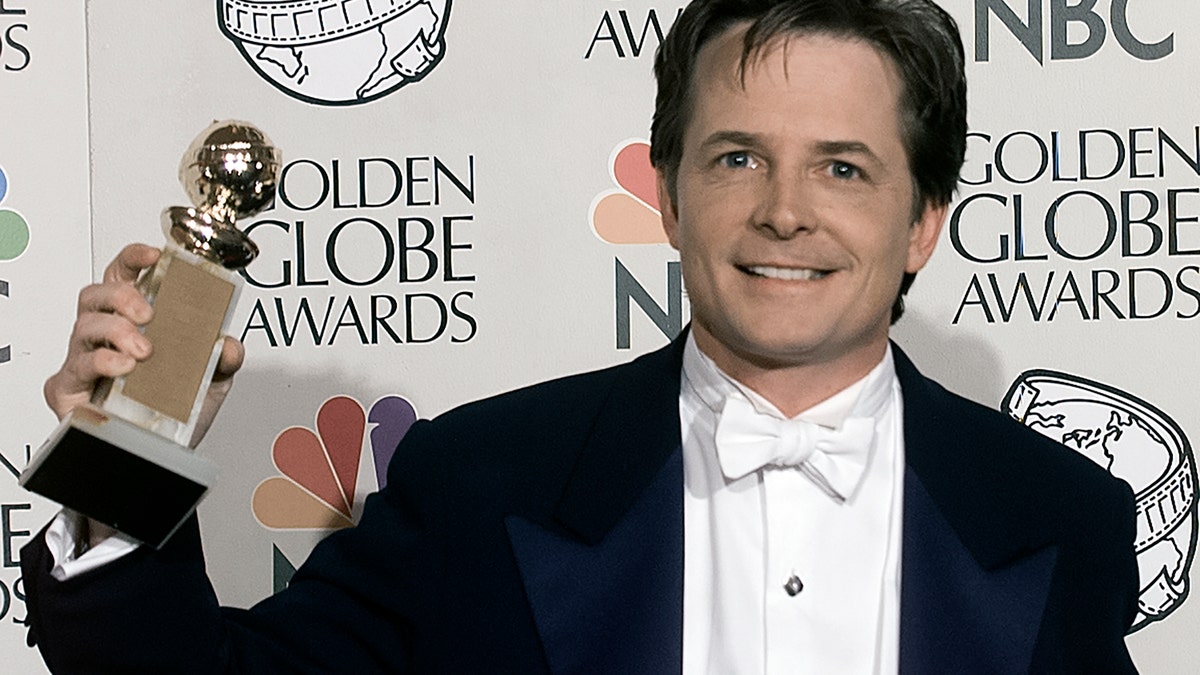 Michael J. Fox poses with his award at the 1998 Golden Globes.