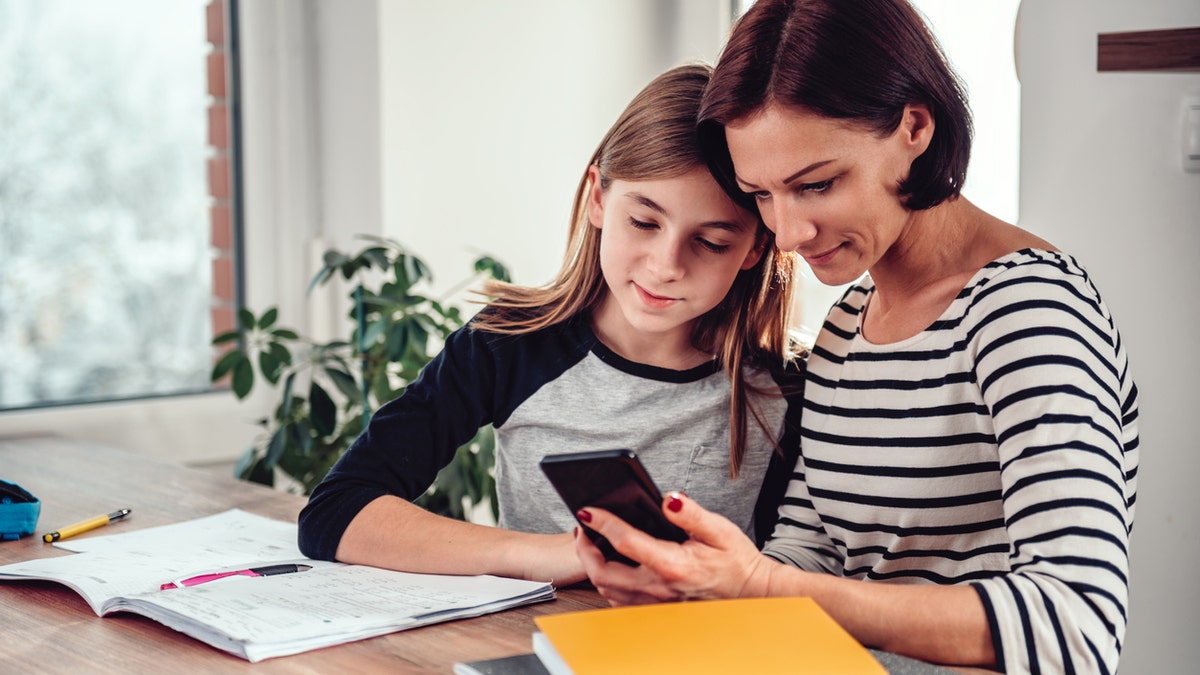 Mom teaching daughter on phone