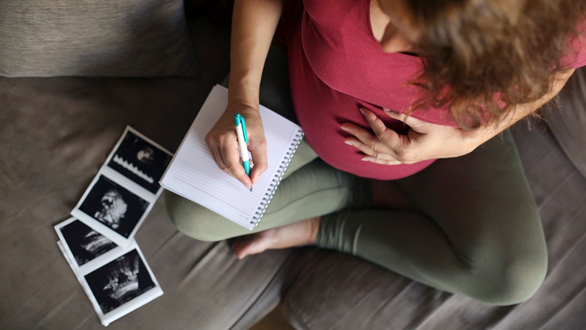 mujer escribiendo nombres de bebé