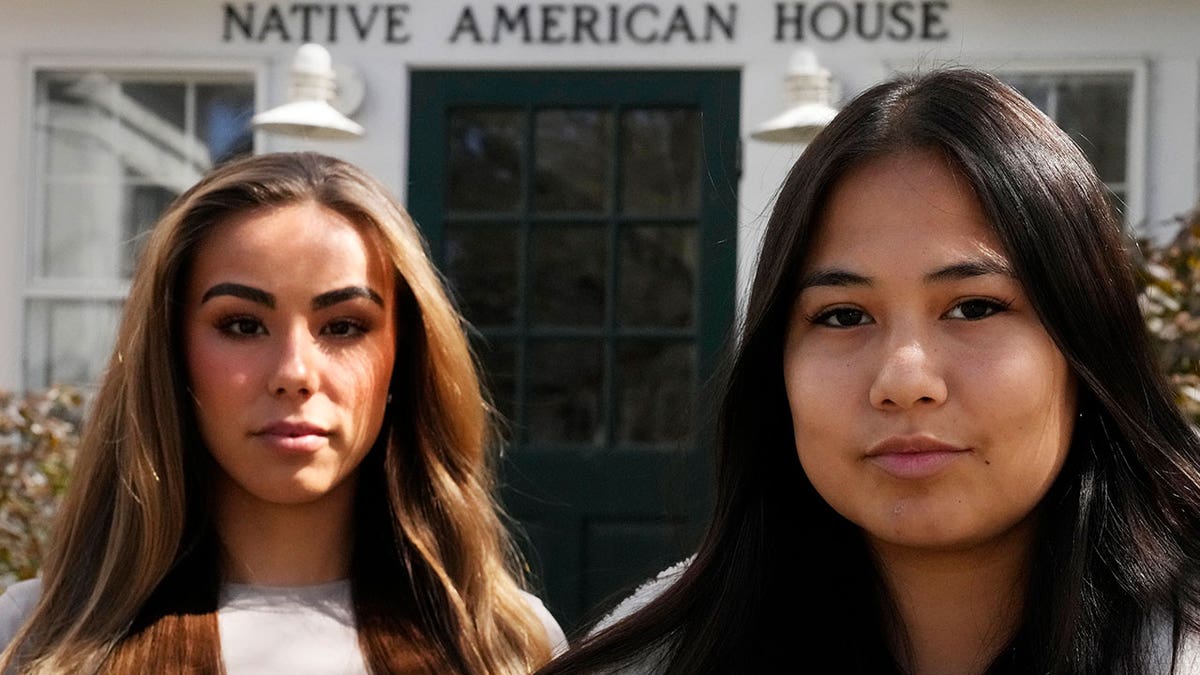 Dartmouth College students and Native Americans Marisa Joseph, right, and Ahnili Johnson-Jennings, left, pose outside the Native American House at Dartmouth College on April 7, 2023, in Hanover, New Hampshire. The college announced that it housed partial Native American remains in their collection. 