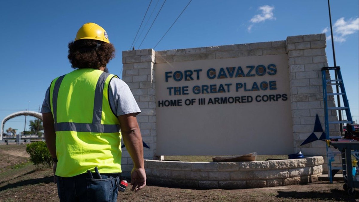 A worker near the entrance sign of the base