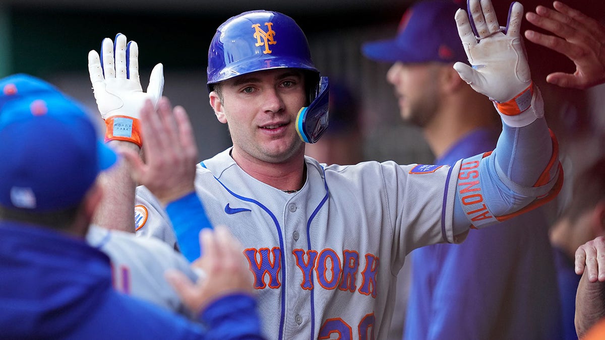 Pete Alonso high-fiving in dugout