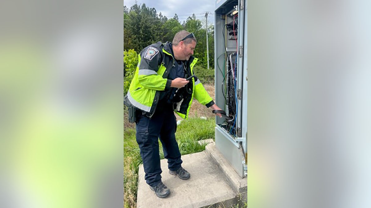officer looking inside electrical box