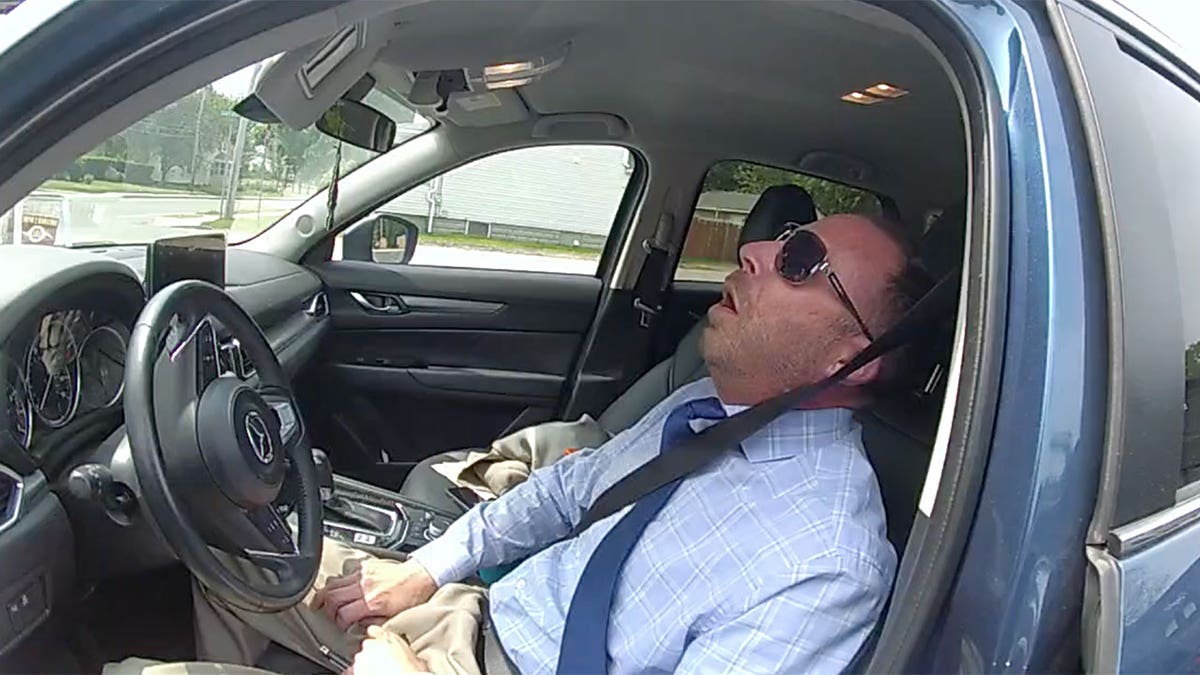 Matthew Reilly is pictured asleep in the driver's seat of his vehicle