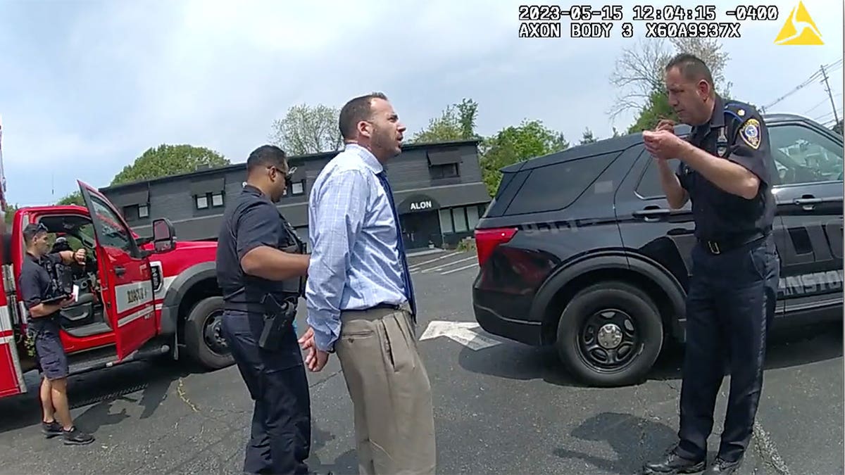 Reilly is handcuffed and led to a police cruiser