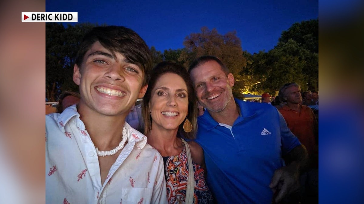 A young teen smiles with his parents in a selfie