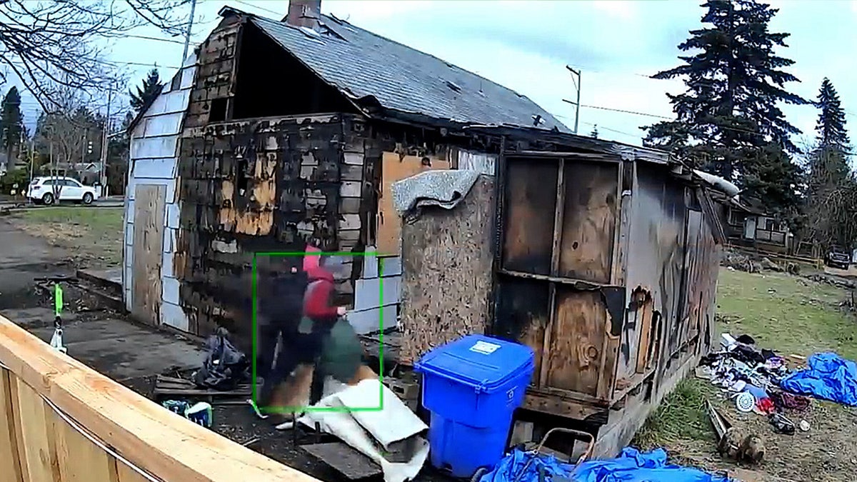 A person walks into a crumbling and burned house in Portland
