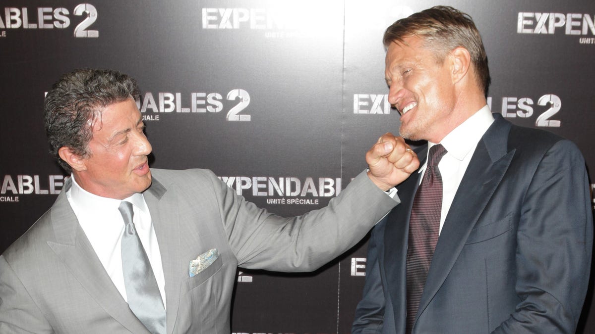 Sylvester Stallone pretends to punch Dolph Lundgren.