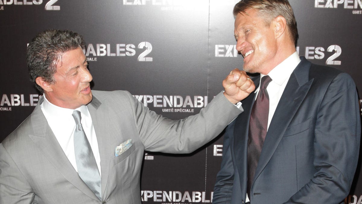 Sylvester Stallone pretends to punch Dolph Lundgren.