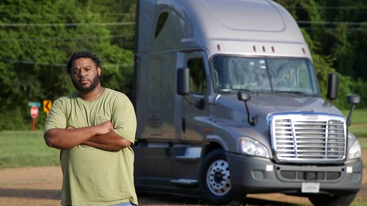 Man stands in front of semi-truck