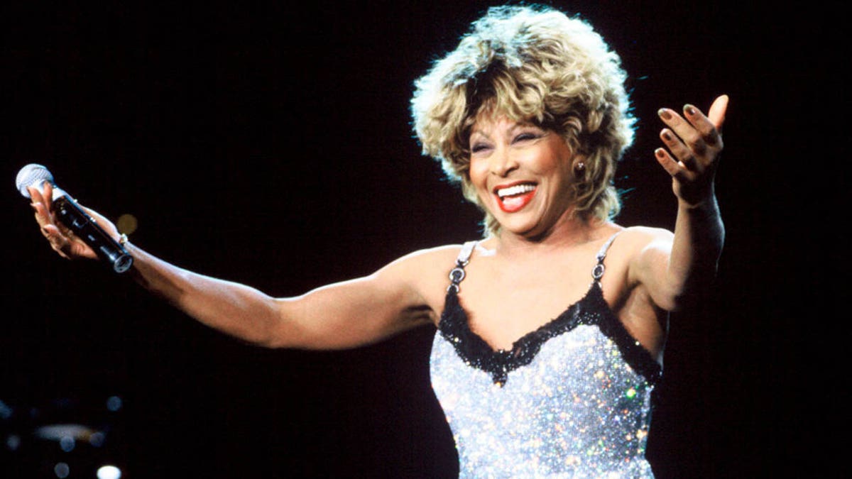 tina turner smiling with arms outstretched on stage