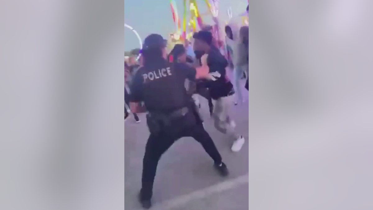 police officer breaking up teen fight