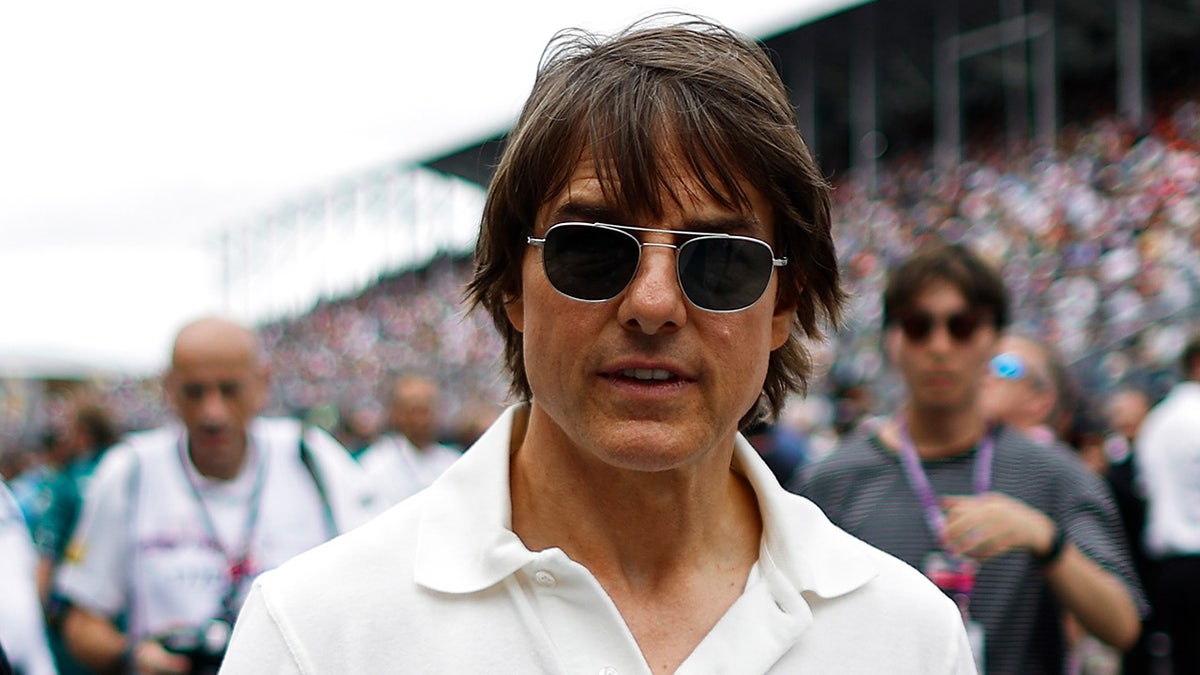Tom Cruise wears white polo shirt and sunglasses at F1 car race