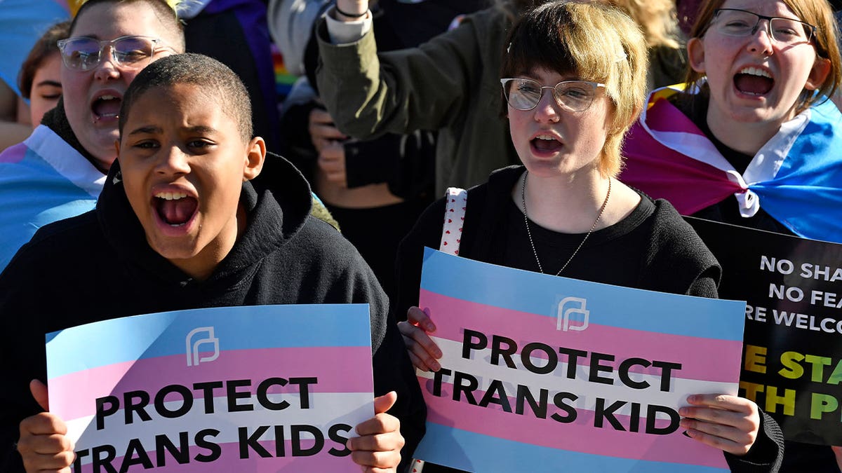 protesters with "protect trans kids" signs