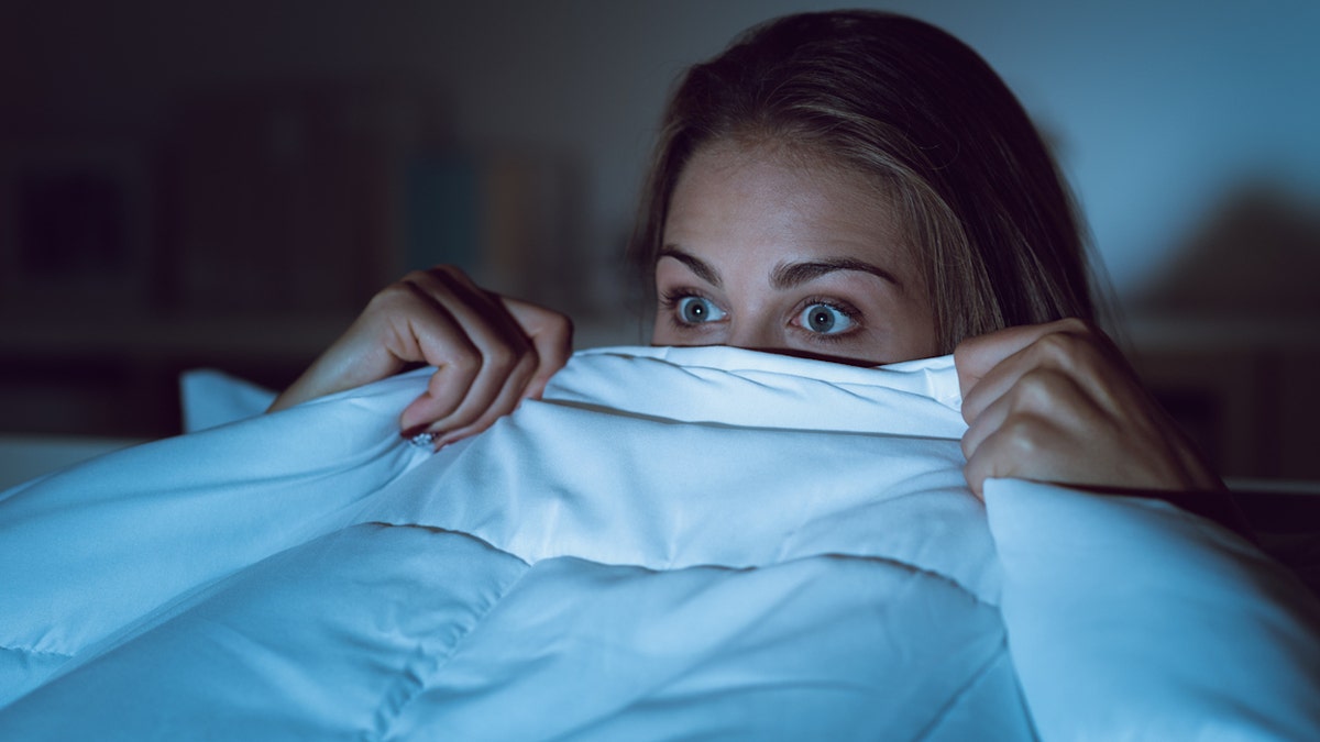 Mujer asustada en la cama